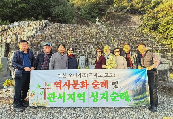 학살당한 조선인 근로자 묘지 앞에서. 순례자들은 작은 조약돌에 기억함의 메시지를 남기는 운동에 동참한다.